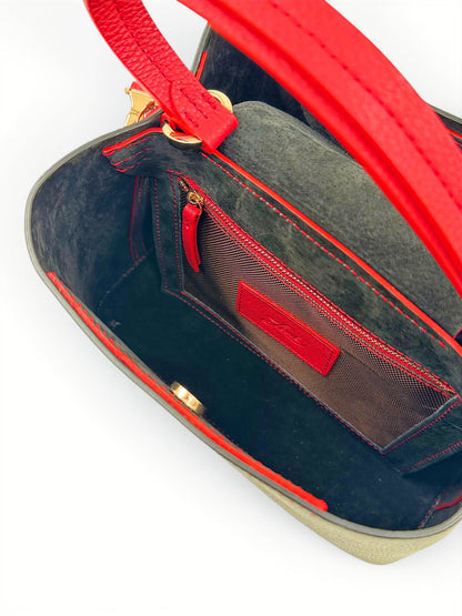 Close-up of a red leather handbag with lining and gold hardware