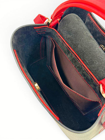 Close-up of a red leather handbag with lining and gold hardware