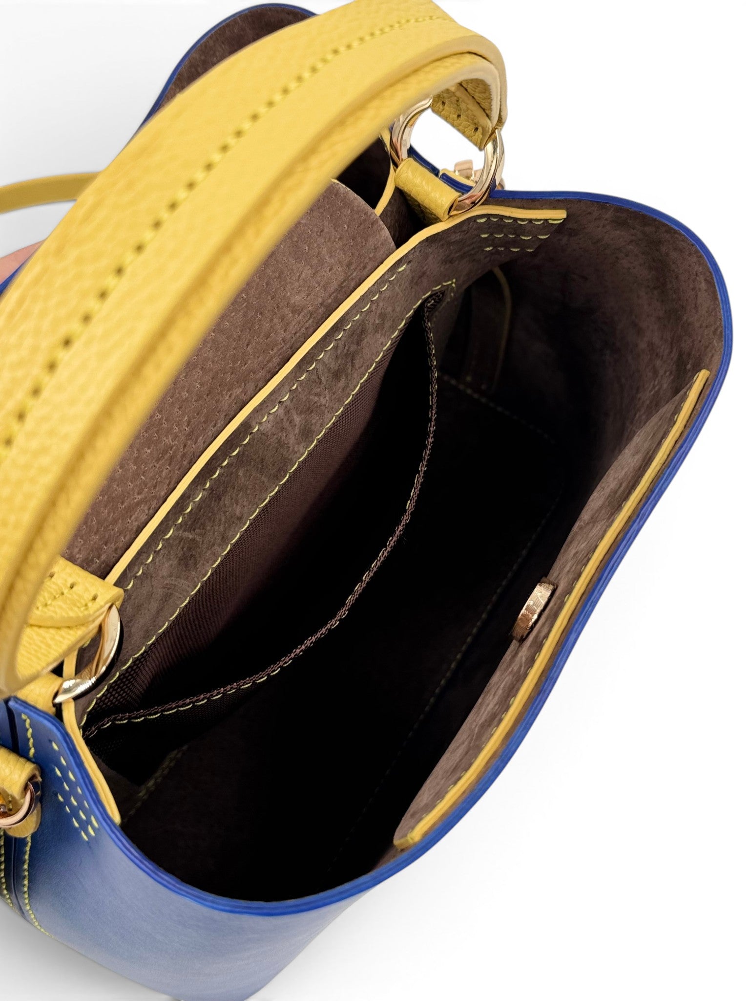 Close-up of a blue and yellow leather handbag with open top, showing interior.