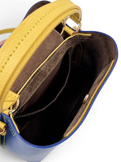 Close-up of a blue and yellow leather handbag with open top, showing interior.