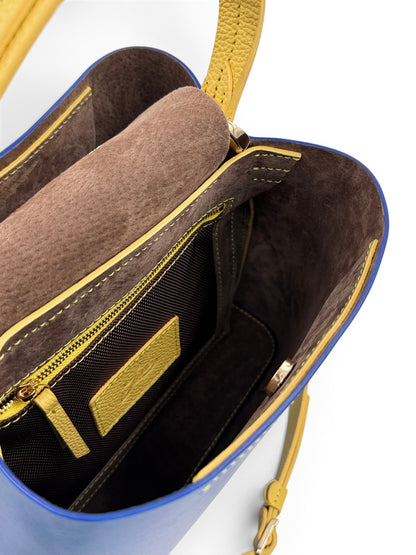 Close-up of a blue and yellow leather bag with gold accents