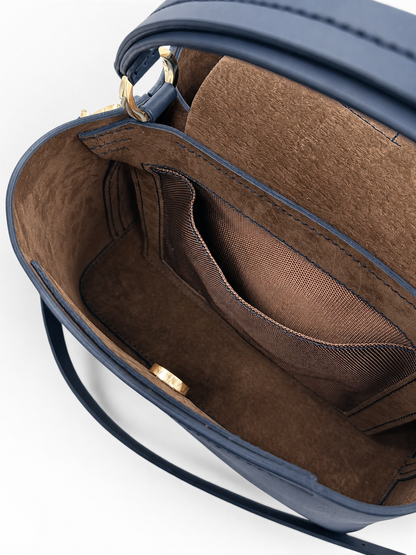 Close-up of a blue handbag with a brown interior