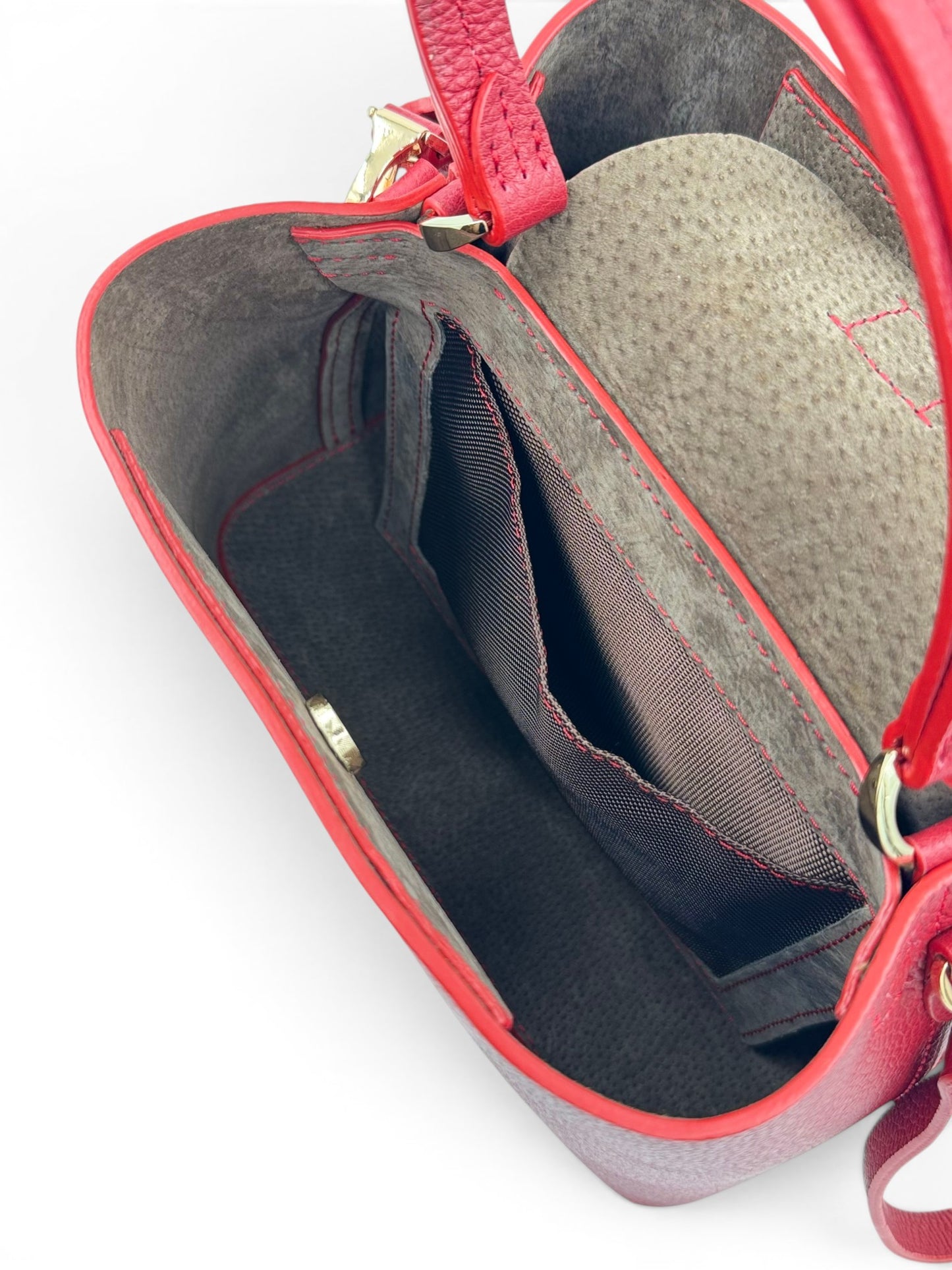 open red leather handbag showing interior with gray lining 