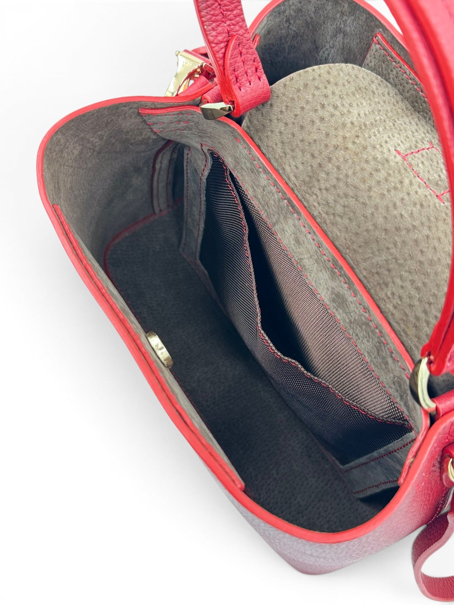 open red leather handbag showing interior with gray lining 