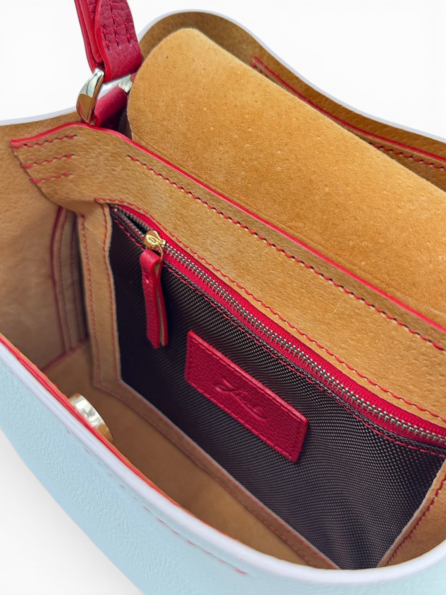 Close-up of a White and red leather bag with pocket with zipper and handle