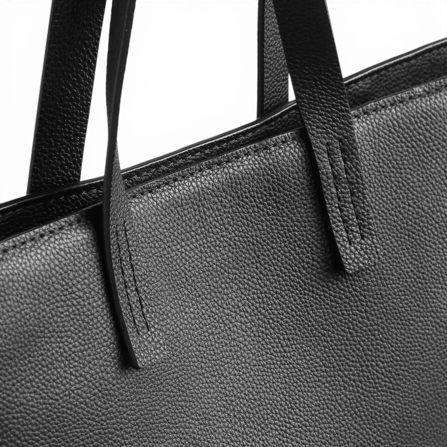 Close-up of a black leather shoulder bag with handles.