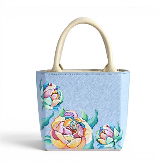 Light blue leather handbag with floral designs