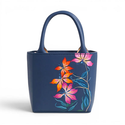Blue leather handbag with floral designs on a white background
