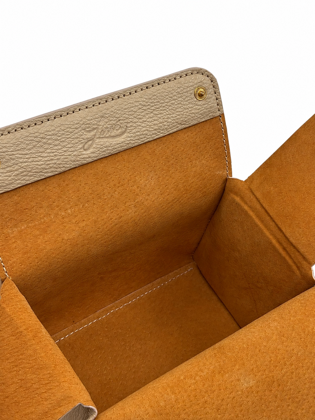 Close-up of a cream leather crossbody bag with a beige interior and visible brand logo.